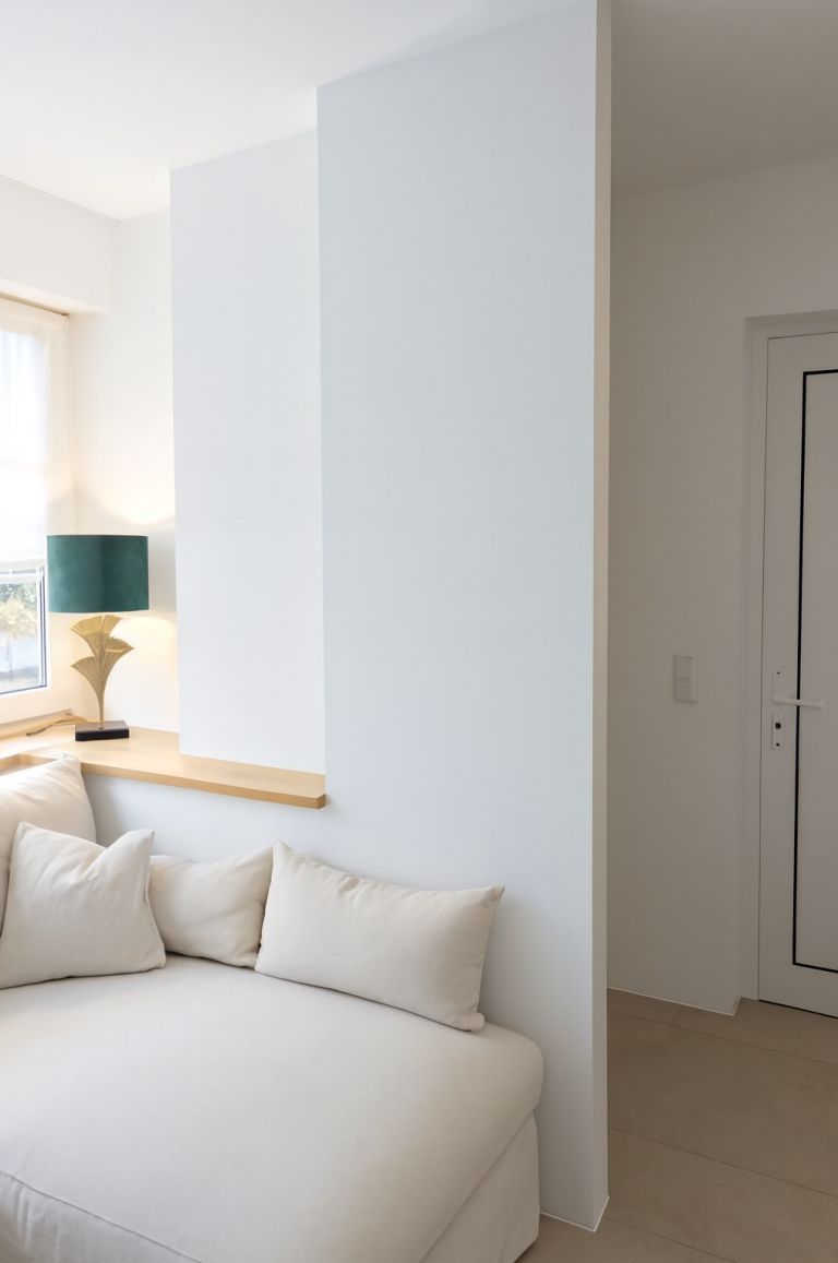 Nachher: Neue Garderobe als klare Raumkante und gemütliche Wohnzonenbildung Fertiggestellte Garderobe als Trennung von Eingangsbereich und Wohnzimmer mit umlaufender Fensterbank.