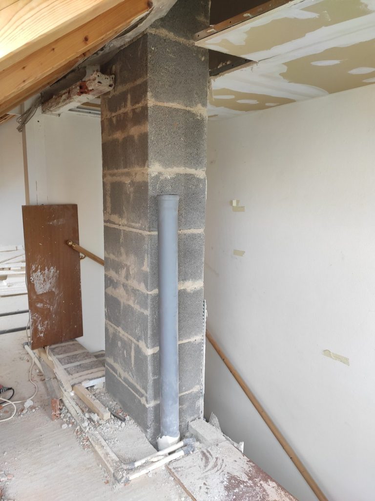 Umbau – Wandöffnung und neue Raumstruktur Geöffnete Wand neben der Treppe während des Umbaus, mit freiliegendem Kaminschacht